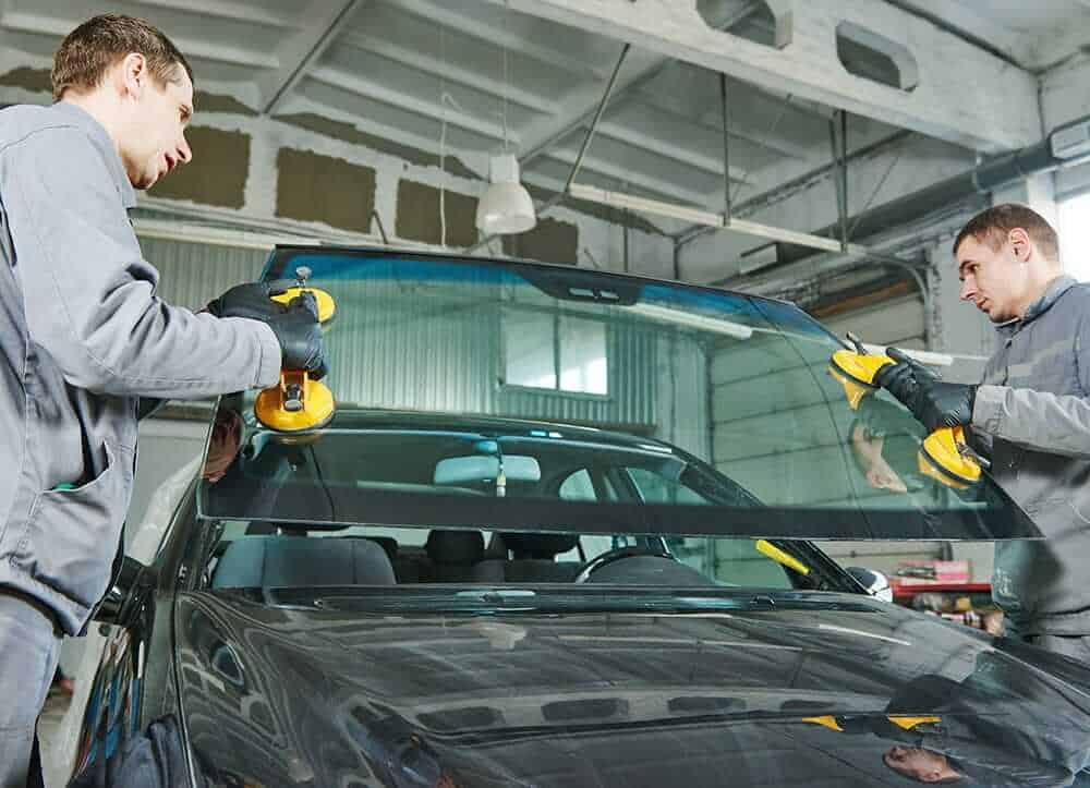 mechanics changing car windscreen