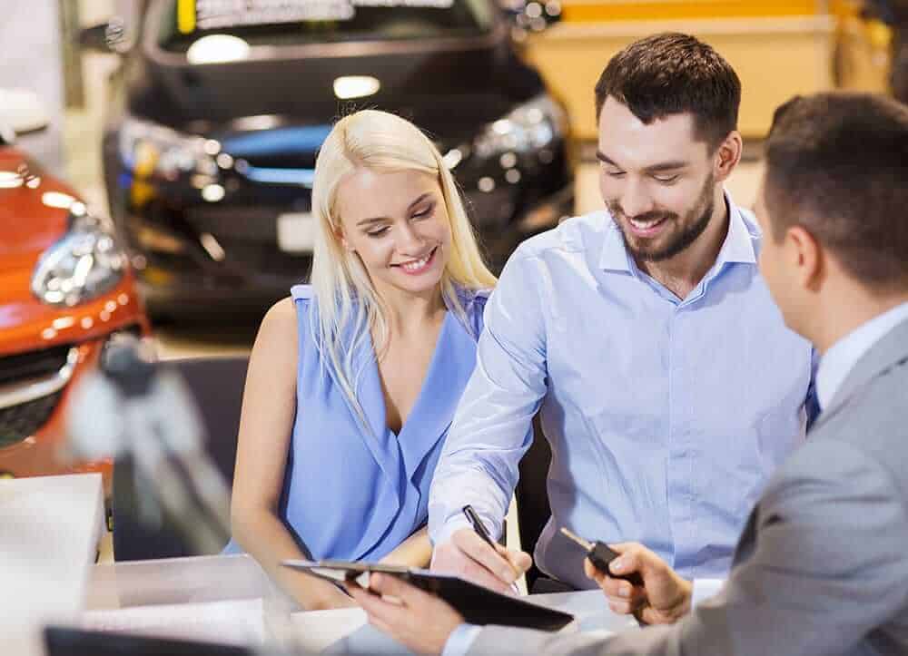 couple is buying a car at dealership