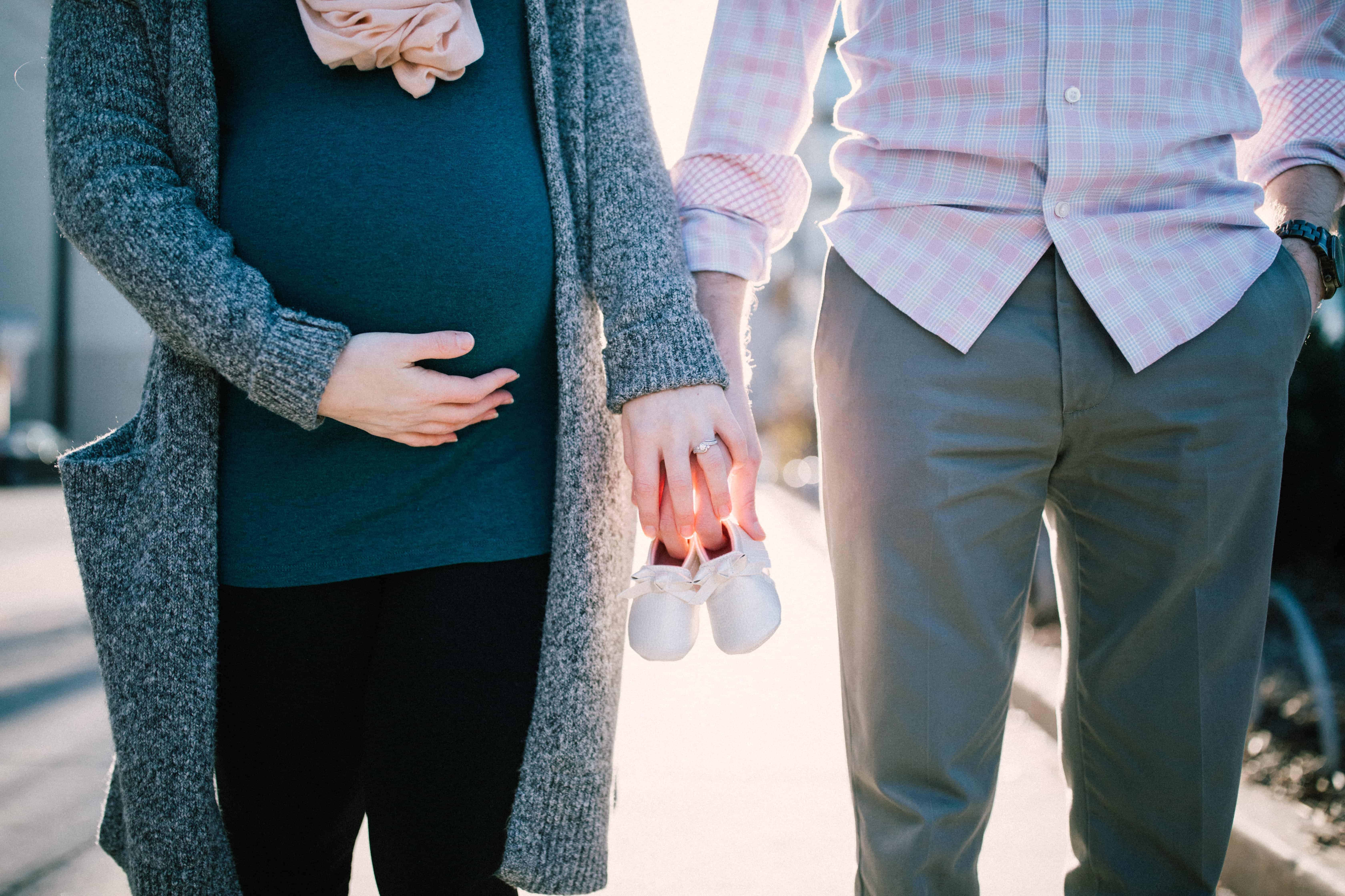Expectant couple holding hands